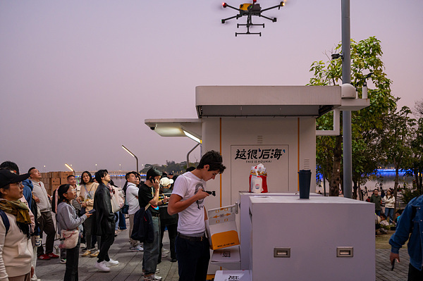 在深圳，外國(guó)游客體驗(yàn)無(wú)人機(jī)外賣(mài)送餐。