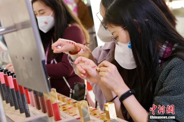 圖為女生正在體驗口紅產(chǎn)品。 殷立勤 攝