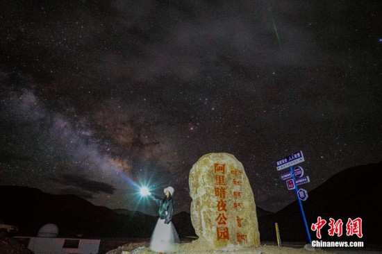 圖為6月20日晚，游客“打卡”西藏阿里暗夜公園，天上是銀河與流星（右上角）。曹枝清 攝