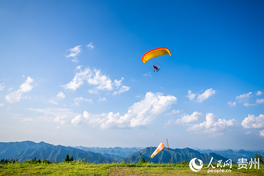 游客在野玉海飛行營(yíng)地乘動(dòng)力滑翔傘體驗(yàn)云端觀景。人民網(wǎng)記者 涂敏攝