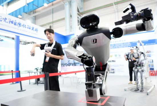 9月5日，在沈陽(yáng)的2025全球工業(yè)互聯(lián)網(wǎng)大會(huì)的展覽區(qū)現(xiàn)場(chǎng)，中國(guó)科學(xué)院沈陽(yáng)自動(dòng)化研究所的機(jī)器人工程師在調(diào)試具身智能操作系統(tǒng)。新華社記者 李鋼 攝