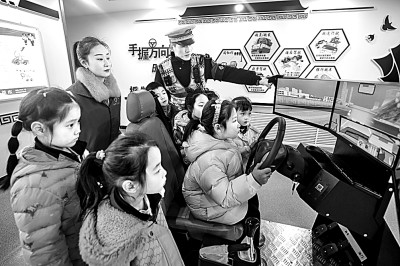 山東省榮成市公安局道路交通安全宣傳教育基地,交警帶領(lǐng)小學(xué)生現(xiàn)場體驗?zāi)M駕駛。新華社發(fā)