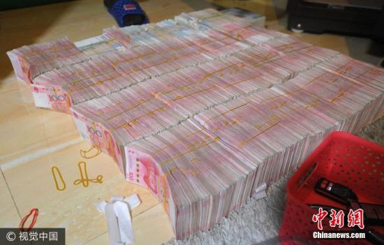 廣西南寧警方8月21日通報,當?shù)亟粘晒善粕姘附痤~15.19億元人民幣的特大傳銷案件。圖為當場繳獲的成捆現(xiàn)金。圖片來源:視覺中國